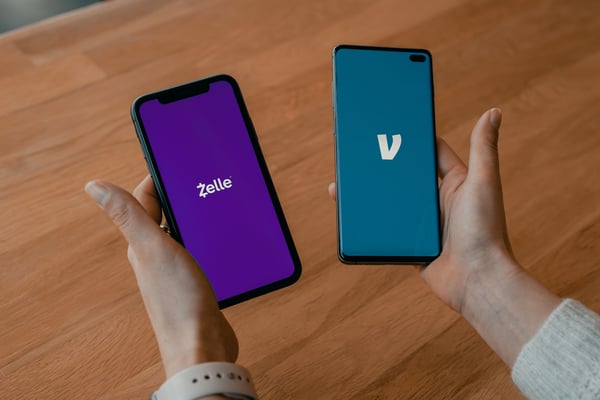 Two Mobile Devices, One Using Venmo, One using Zelle Peer-to-Peer Payment Methods